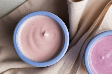 ogurts assortment  in ceramic bowls on wooden light background. Natural and fruit  healthy, diet, gourmet dessert for granola breakfast. Sweet yoghurts closeup.
