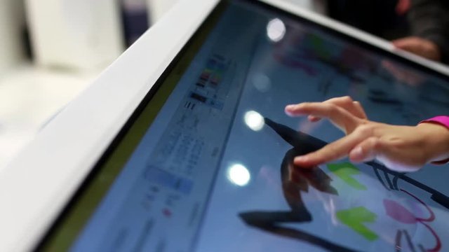 Woman Draws a Finger on the Large Touch Screen