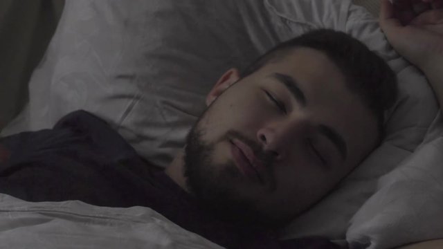 Man waking up in bedroom