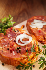 Marinated, raw pork ready for roasting on a wooden table.