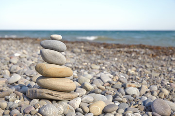 Fototapeta na wymiar Stone pyramid on a pebble beach