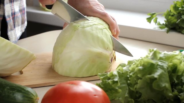 Cook cutting cabbage on a cutting board