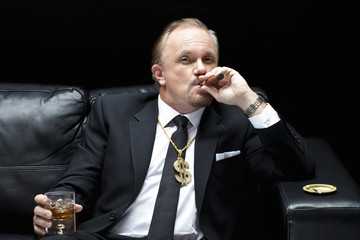 mafia boss smoking a cigar while drinking whiskey.