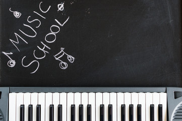 Music keyboard on blackboard background for music school children with copy space