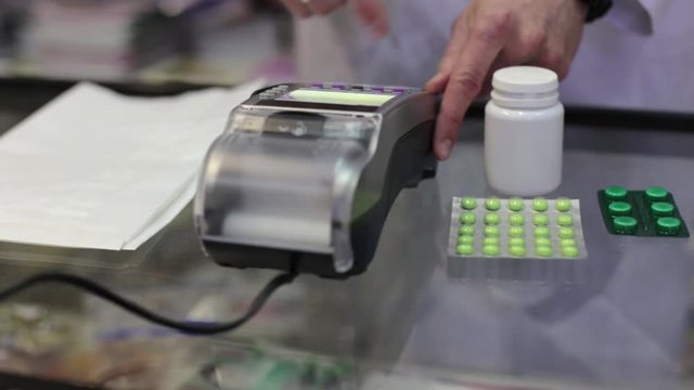 Woman Paying with a Phone at the Pharmacy