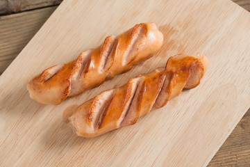 Grilled sausages on wood board.