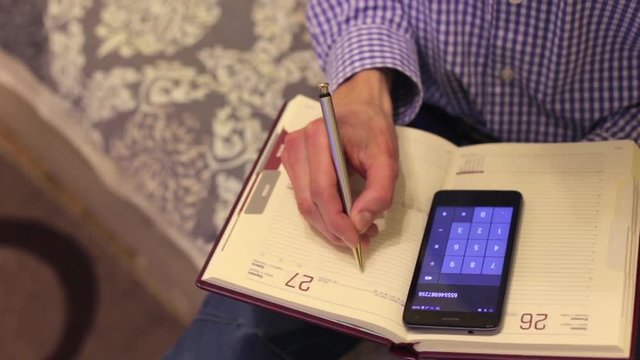 Man doing calculations with a smartphone