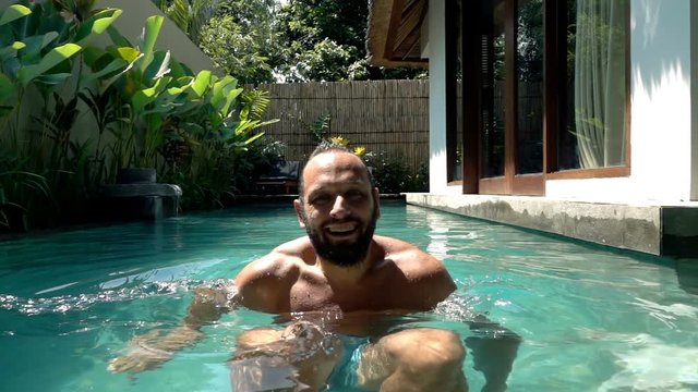 Happy man swim in the pool, super slow motion, shot at 240fps
