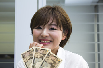 3万円を持った笑顔の女性
