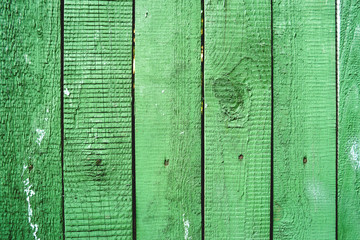 Wooden background of old fence with rusty nails. Shabby texture of green wooden boards.
