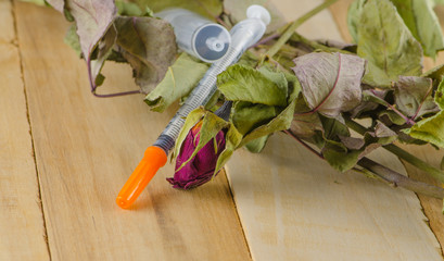 dried rose and syringe