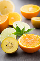 Mixed citrus fruit lemons, orange, kiwi, limes on a gray backgro