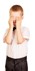 Crying boy covers his face with hands isolated on white.