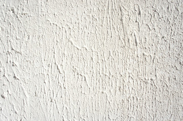 Plaster wall texture. White stucco textured wall background with natural light