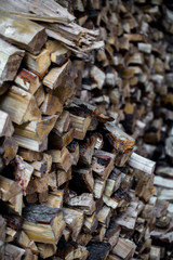 very large pile of firewood, stacked in an old barn