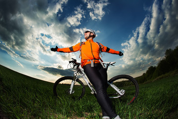 Naklejka premium Man Cyclist with bike on sunset