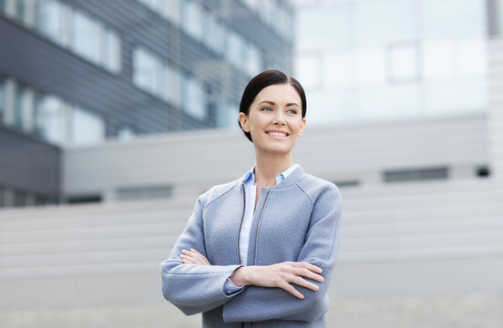 young smiling businesswoman over office building