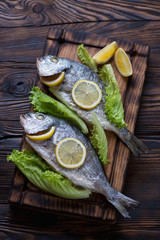 Two baked sea breams with lemon and fresh salad