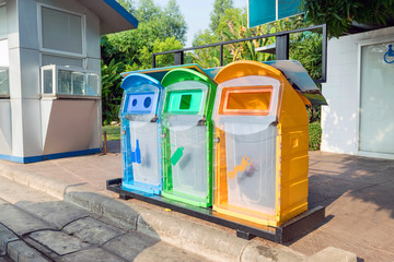 Colorful plastic bins for different waste types in the park.