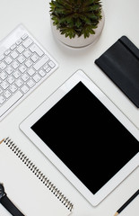 Tablet mock-up and office supplies on white tabletop background