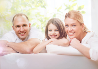 smiling parents and little girl at home