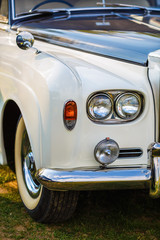 Close-up of the front part of the luxury retro car. Old vintage car. Selective focus on the car's headlight. © Veresovich