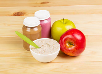 Jar mashed,  bowl  oatmeal and apples on  background light wood.