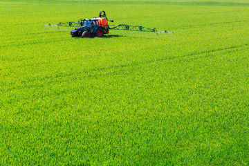 tractor spraying glyphosate pesticides on a field