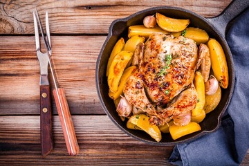 Roasted whole chicken with potatoes and thyme
