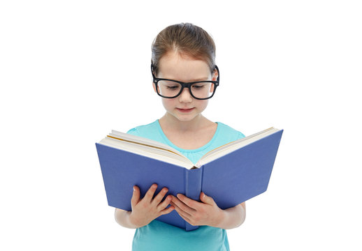 happy little girl in eyeglasses reading book