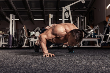 Fototapeta na wymiar Portrait of a man doing push ups exercise with one hand