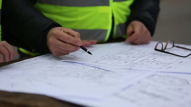 Engineer hands on office blueprints