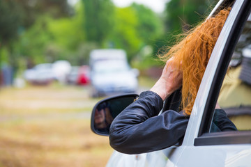 eine Frau sitzt in einem Auto und beobachtet jemanden mit einem Fernglas