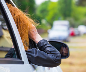 eine Frau sitzt in einem Auto und beobachtet jemanden mit einem Fernglas