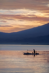 Fototapeta na wymiar Oriental fisherman in the sea at sunrise
