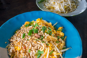 Dish of Thai fried noodles with eggs. It is served with raw fresh bean sprouts.