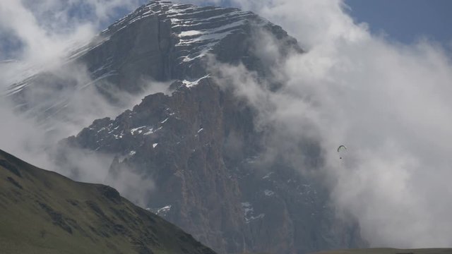 Paragliders on the background of mountains and clouds