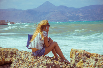 Blonde beautiful girl dreaming at sea beach