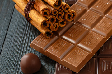 Different chocolate with cinnamon on dark wooden boards