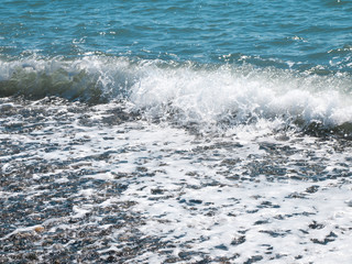 Fototapeta na wymiar Wave splash on pebble beach