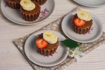 Banana muffins with strawberry on wooden background