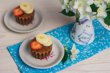 Banana muffins with strawberry on wooden background