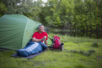 The man sitting next to mobile phone charges from the sun.