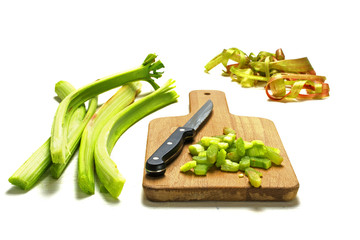 sliced rhubarb and a kitchen knife on a cutting board isolated on white