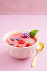 Raspberry smoothie bowl with blueberries, white chia seeds and raspberries in a bowl