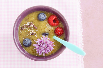 Kiwi smoothie bowl with blueberries, kiwi, white chia seeds, cocoa nibs and raspberries in a bowl