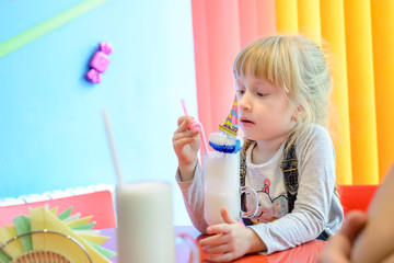 Adorable pretty little girl drinking a milkshake