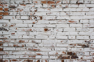 Dilapidated brick wall painted in white color.