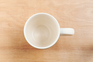 White cup top view on wooden table