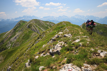 Fototapeta na wymiar Beautiful couple with backpacks traveling in Visitor Mountains, Montenegro